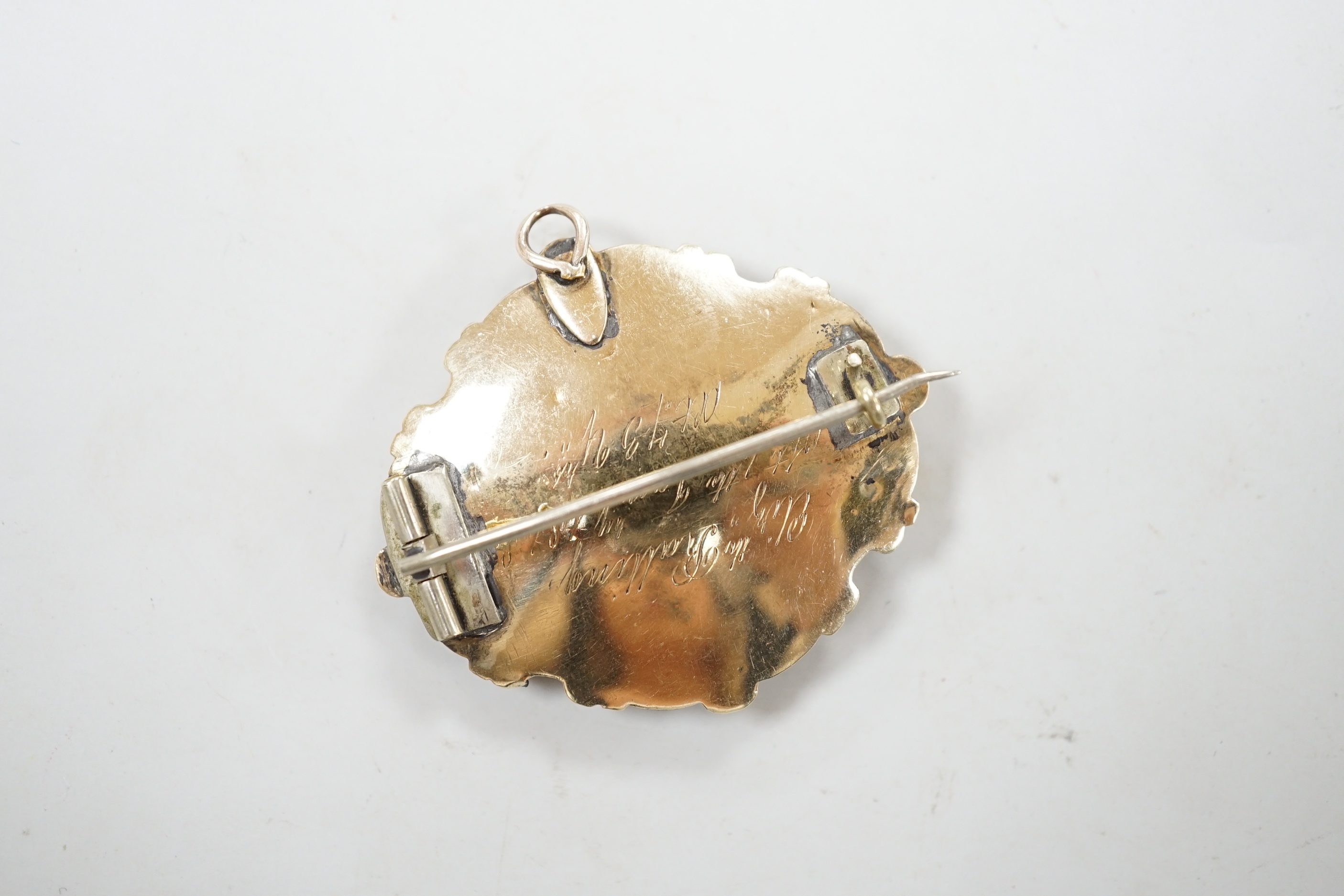 A Victorian 9ct gold, black enamel, plaited hair and seed pearl set mourning buckle ring, size P and a similar yellow metal brooch